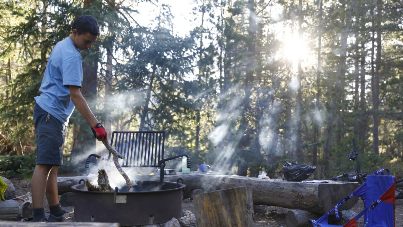 Boy cooking on a grill.