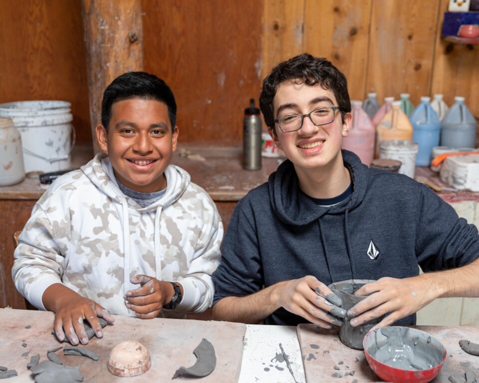 Boys smiling with clay.