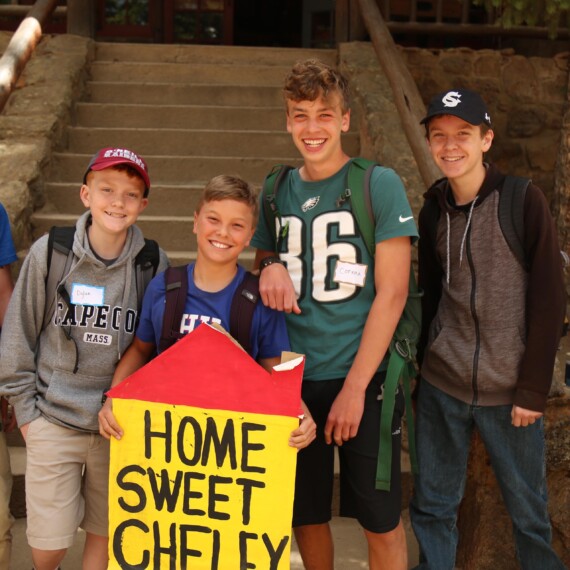 Boys smiling holding sign.