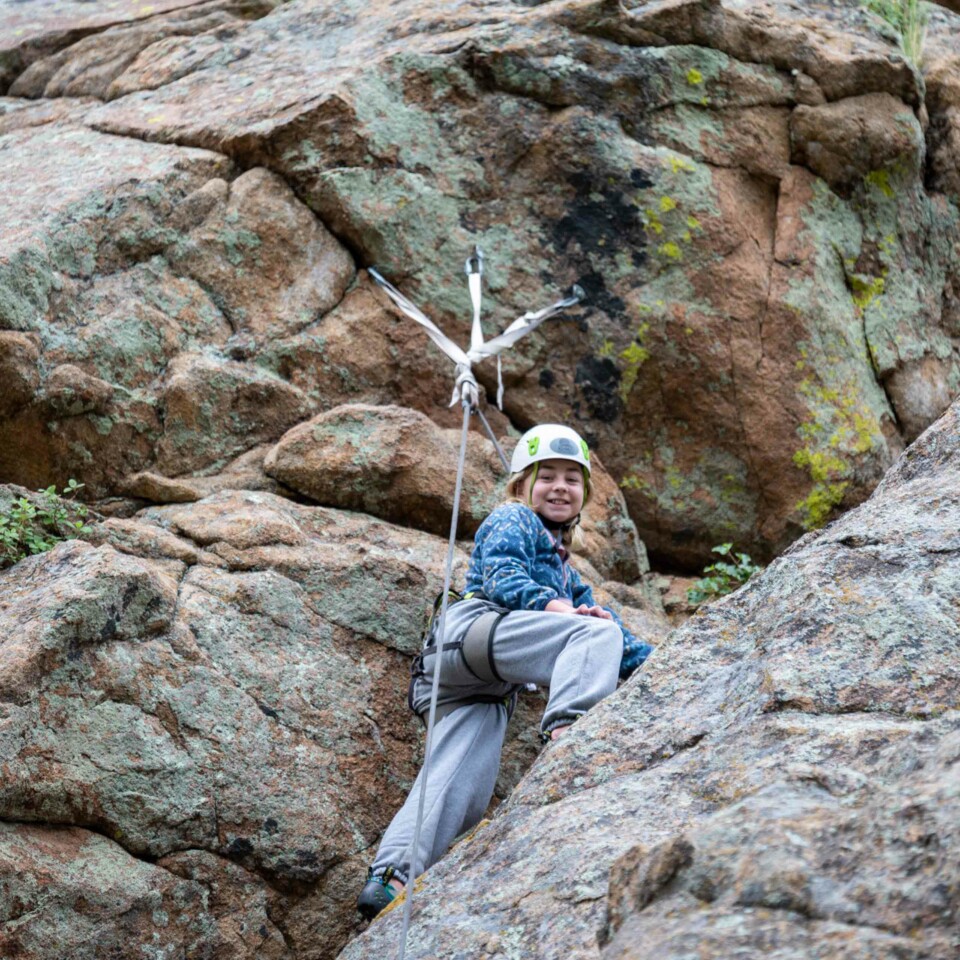 Girl rock climbing and smiling.