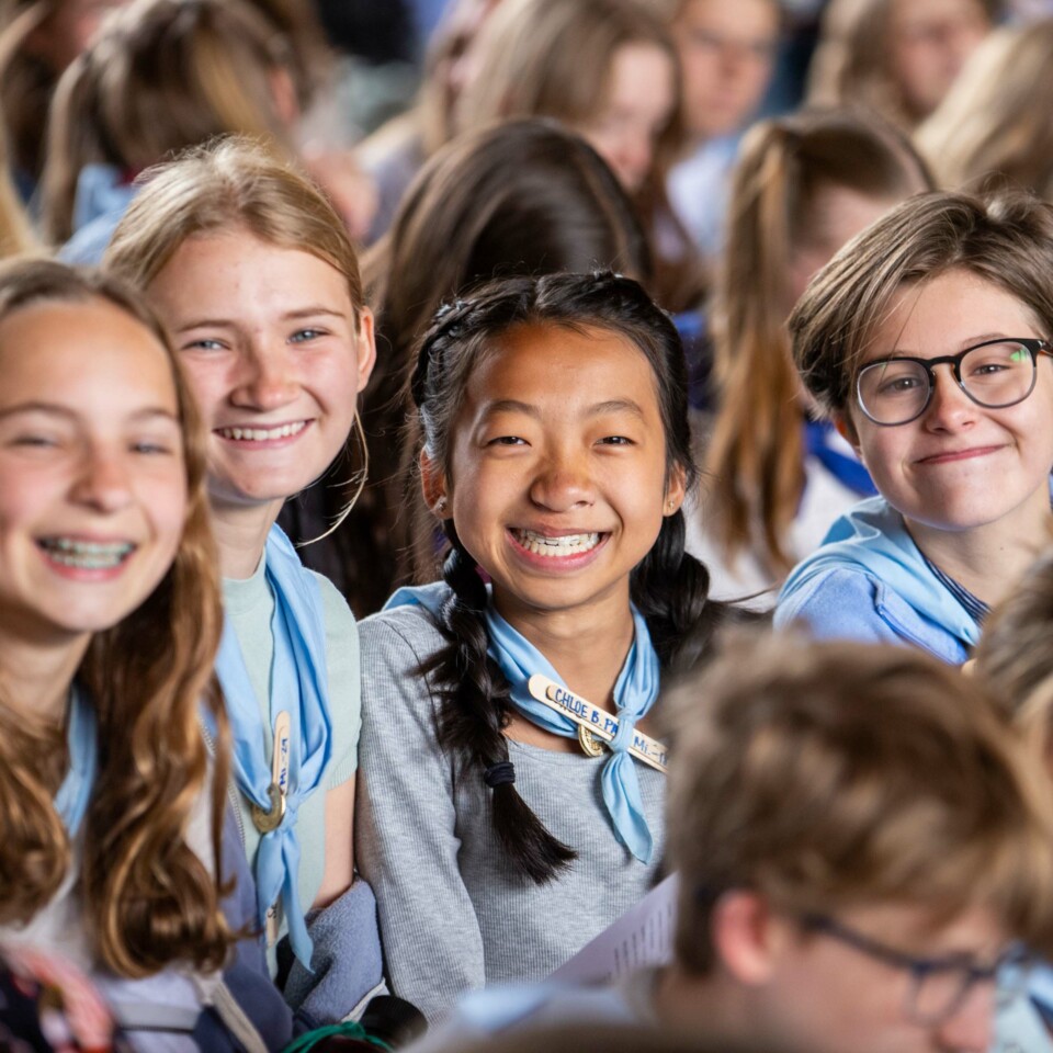 Girls smiling in crowd.