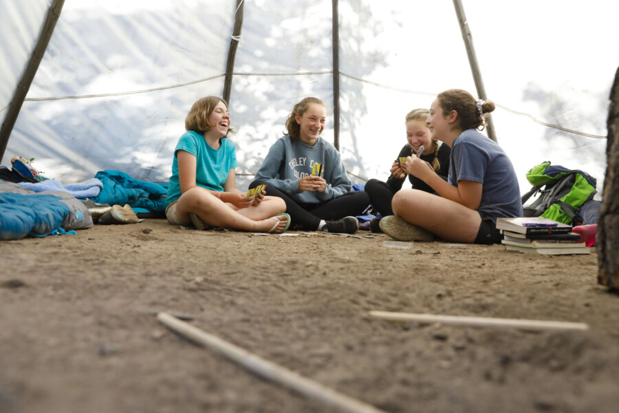 Girls playing cards in tent.