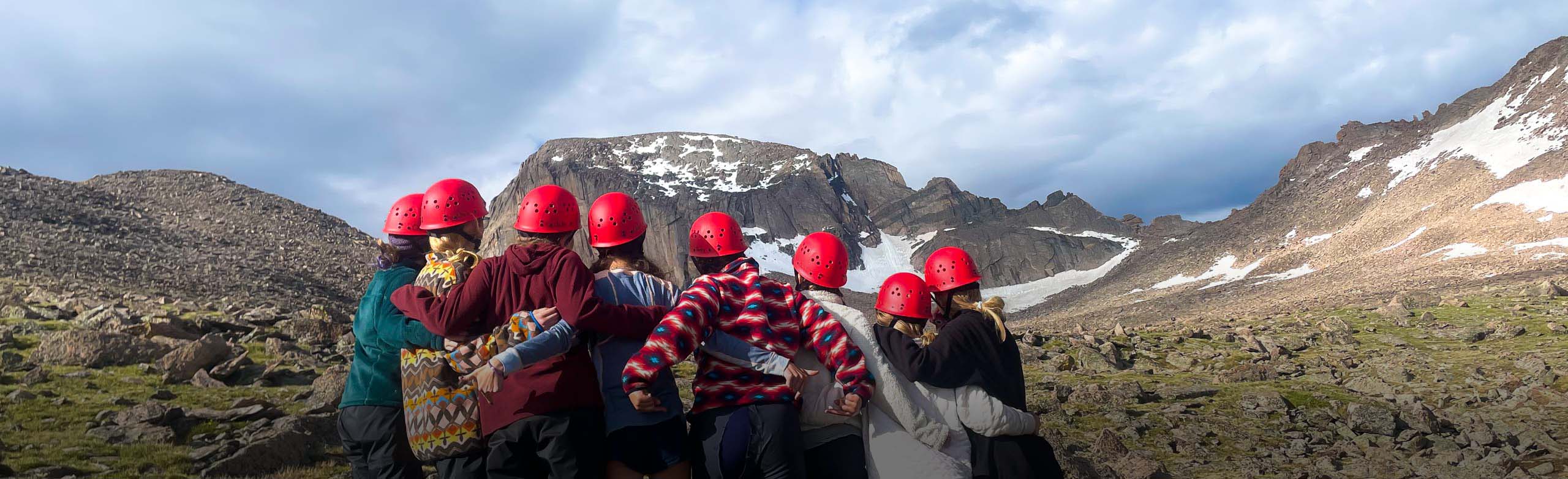 Kids posing facing away toward mountain.