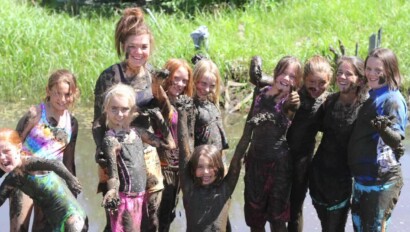 A group of campers playing in mud.