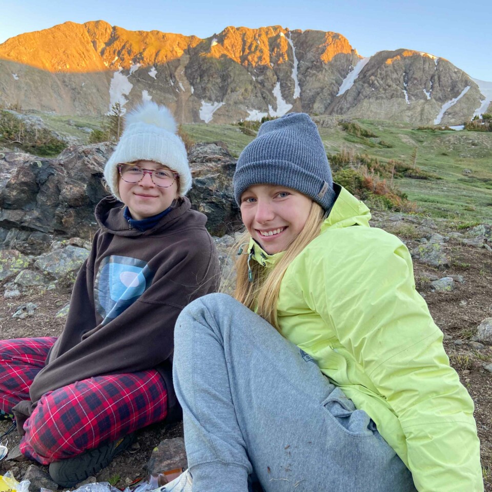 Two girls smiling on mountain.