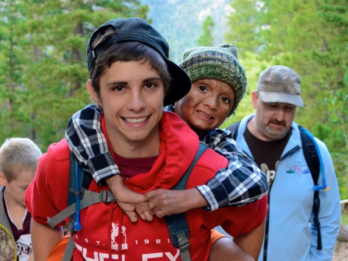 Boy carrying other boy on back.