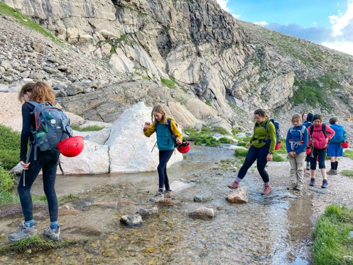 Girls walking across stream.