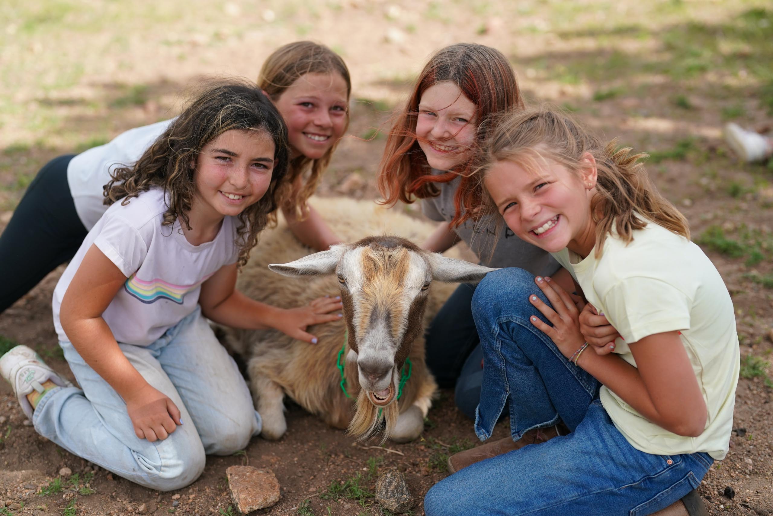 Girls posing with goat.