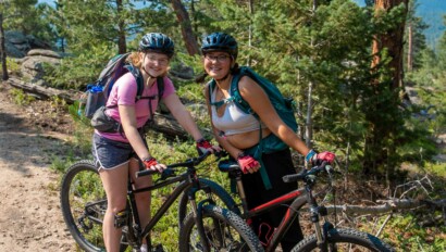 Two girls posing on bikes.