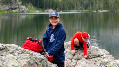 Boy smiling on rock.