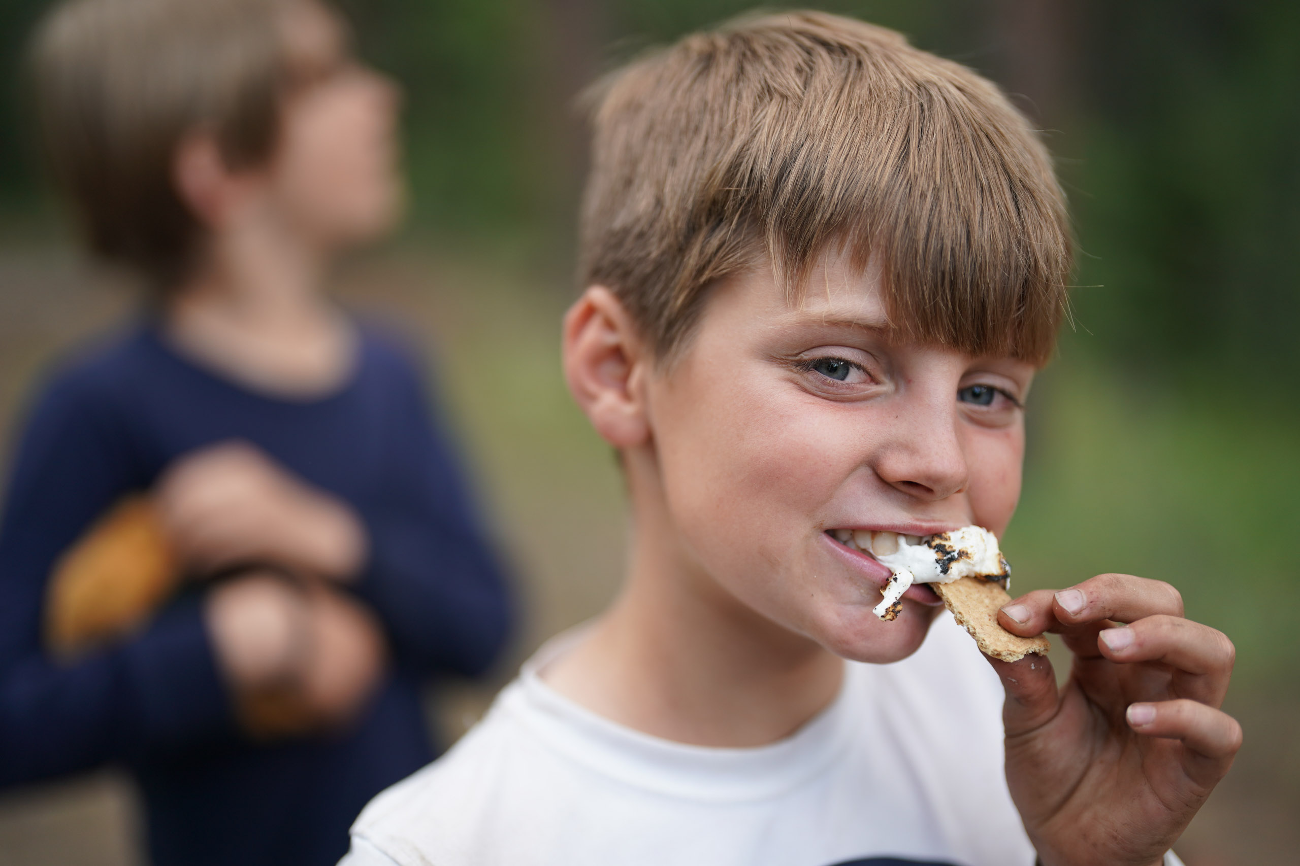 Boy biting smore.