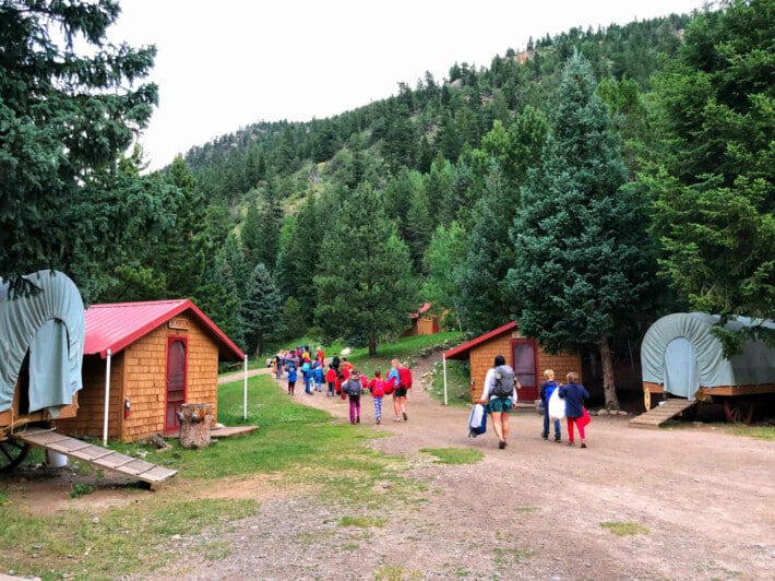 Campers walking into camp with their bags.