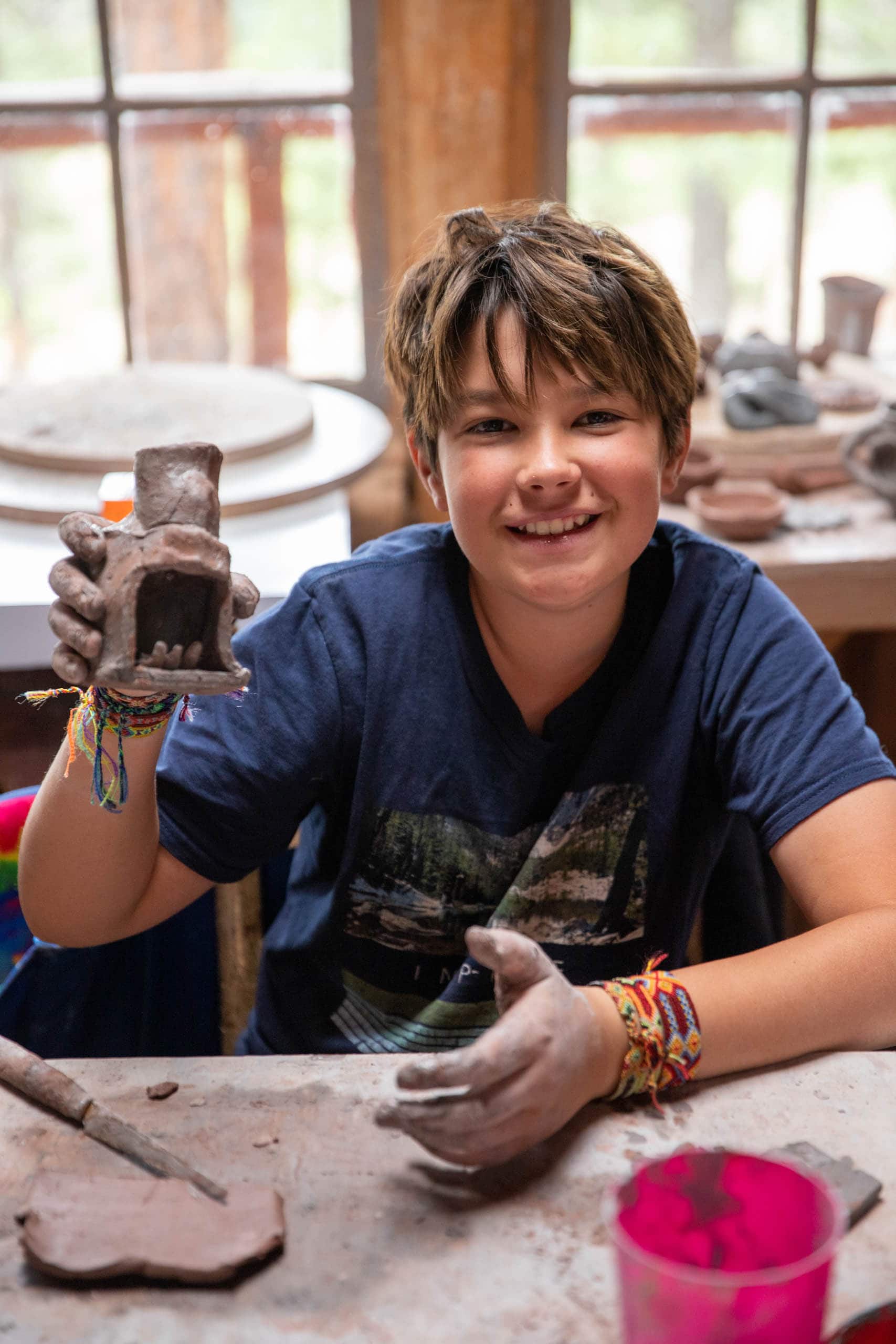 Boy showing his ceramic creation.