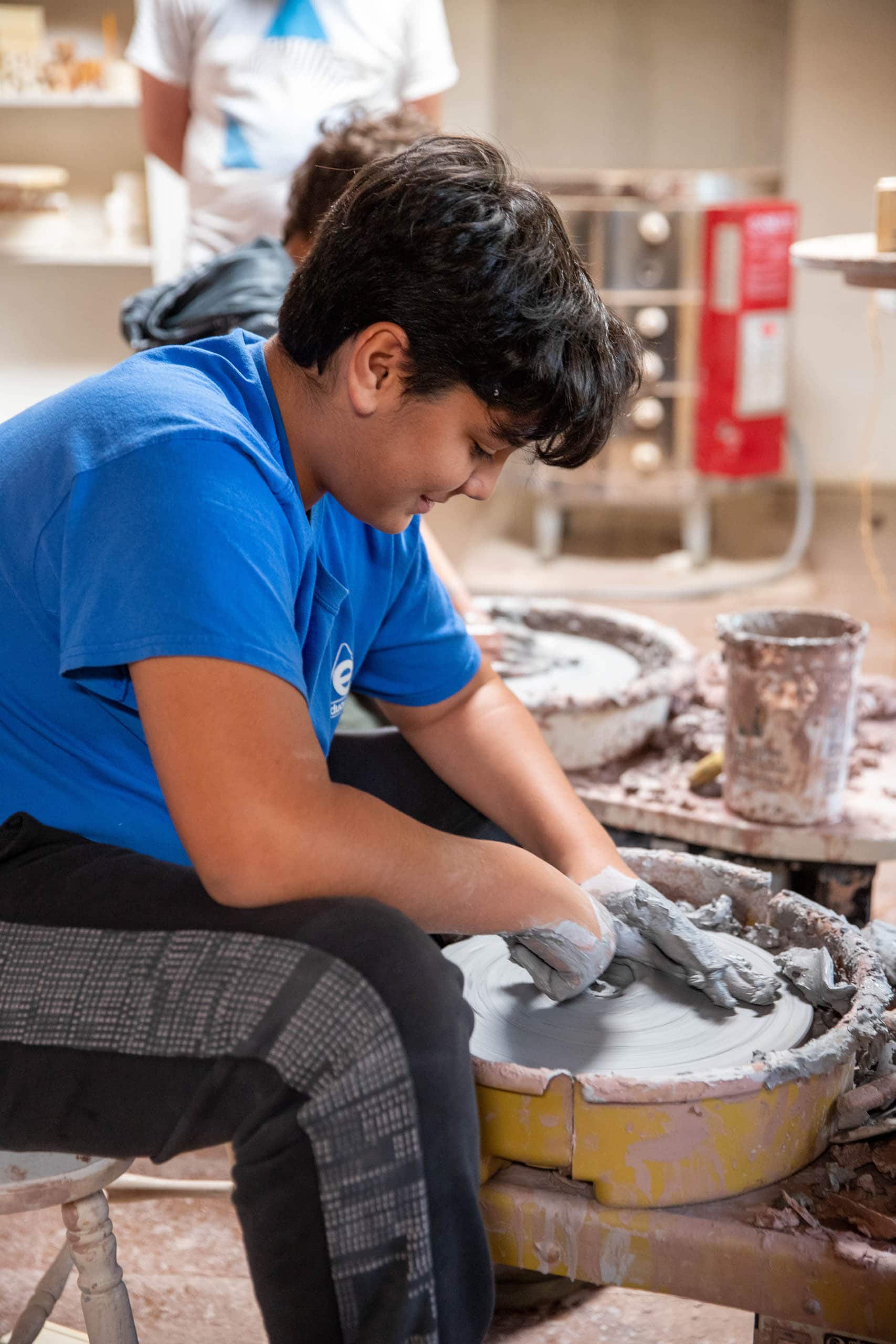 Boy working on the pottery wheel.