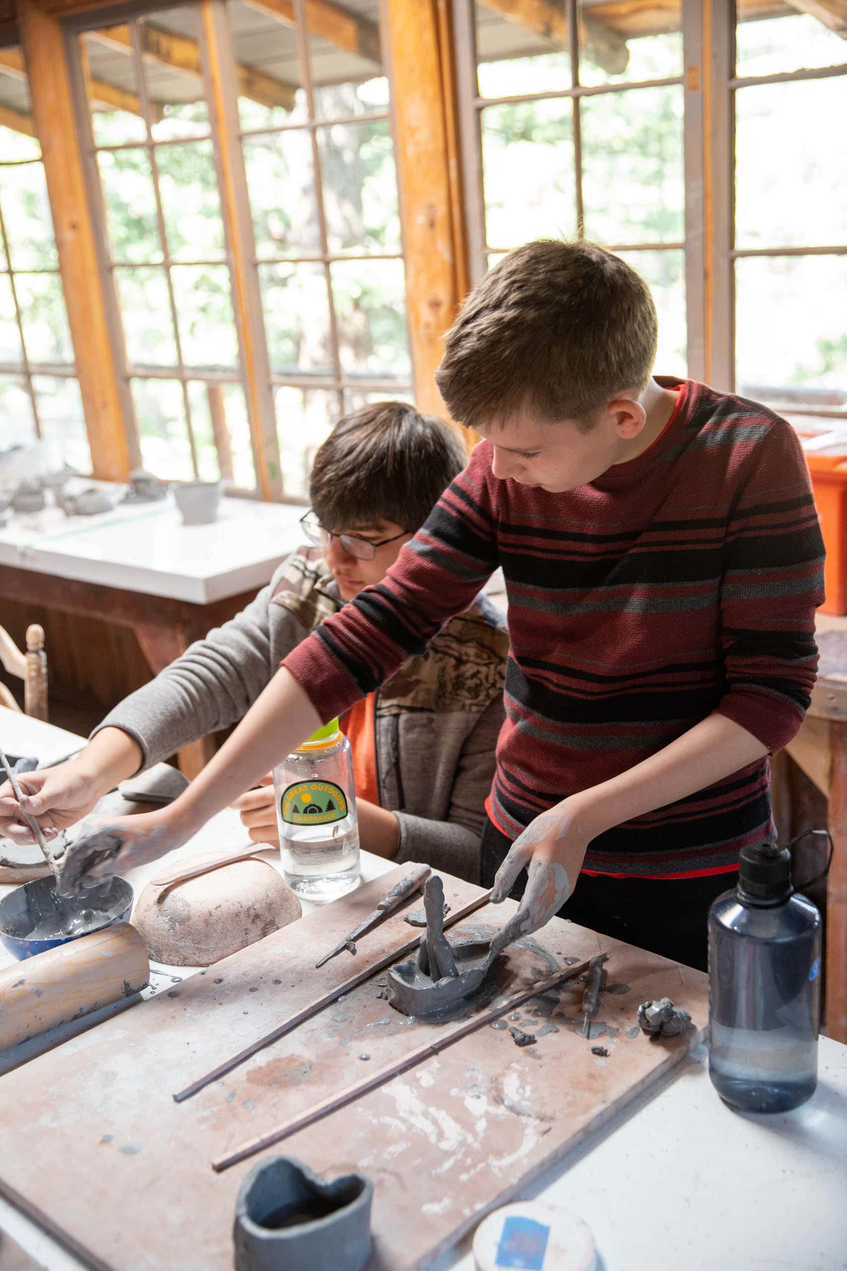 Two boy campers working on hand building ceramics.