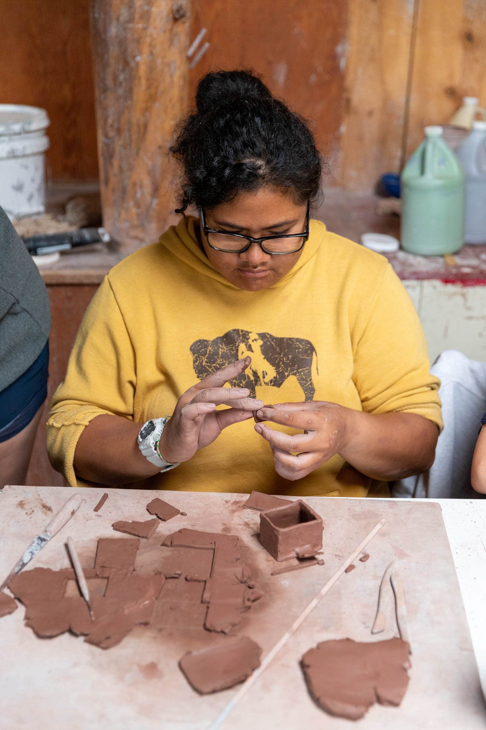 Girl camper working on hand building ceramics.