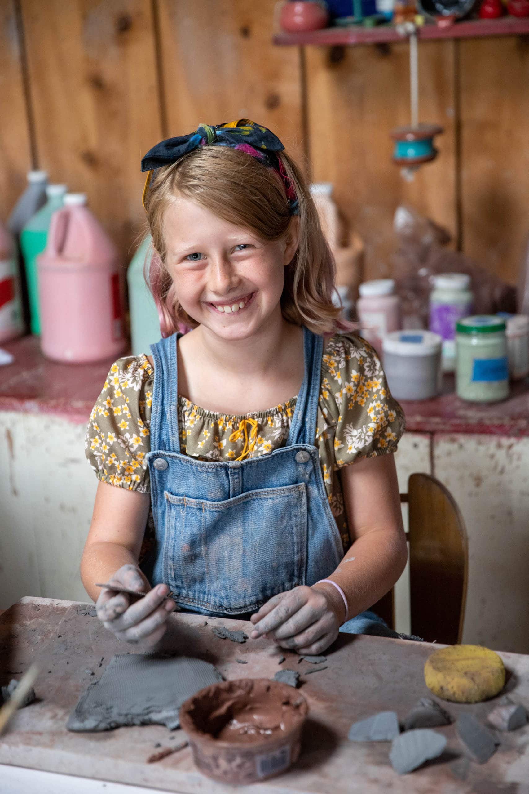 Girl camper working on hand building ceramics.