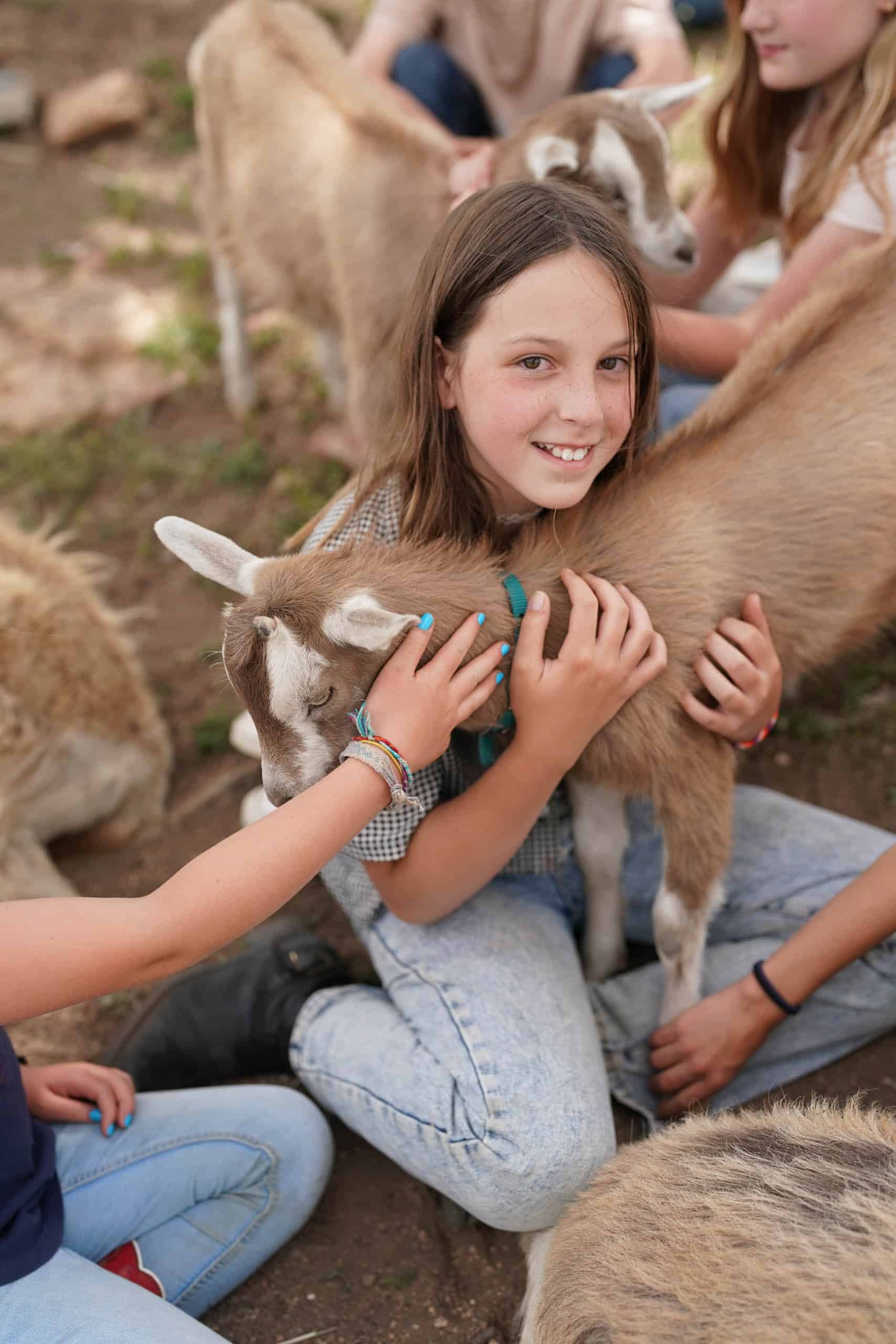 Campers hugging a goat.