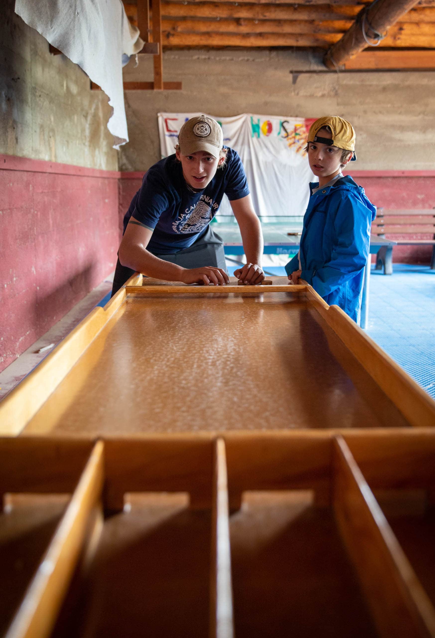 Campers playing indoor shuffleboard.