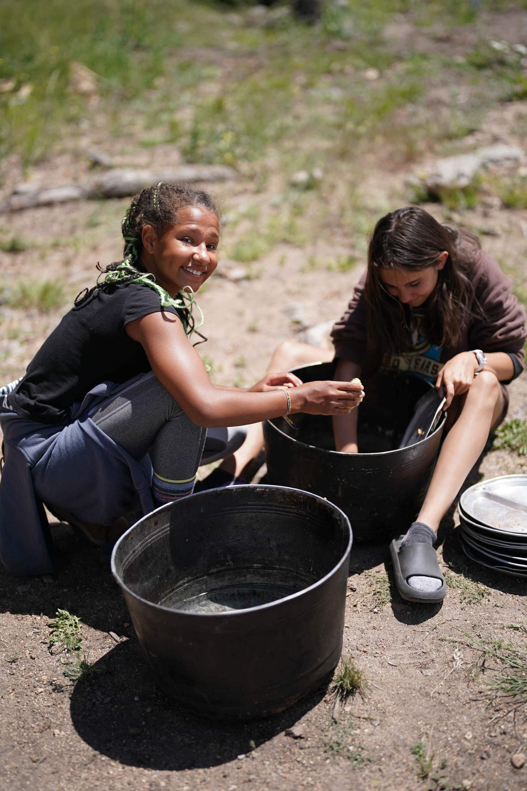 Campers washing dishes outside.