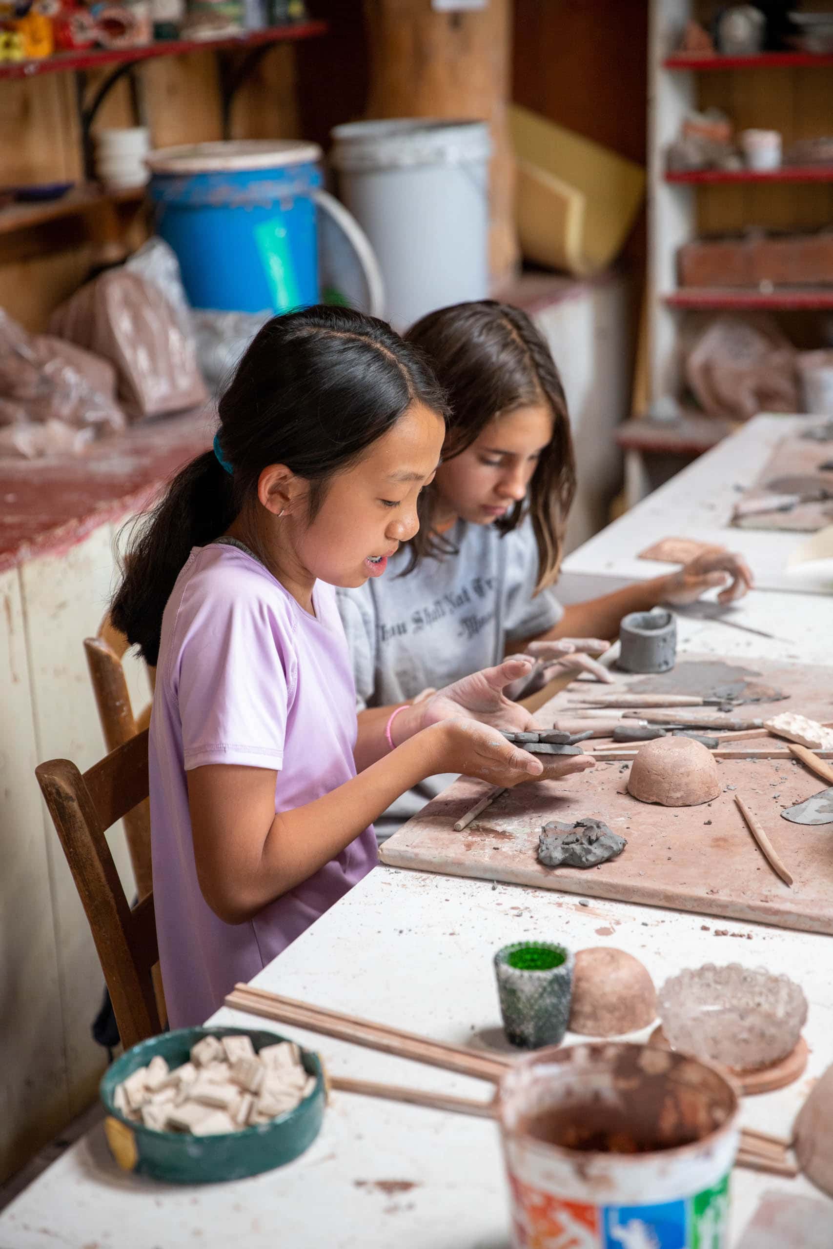 Two girls hand building with clay.