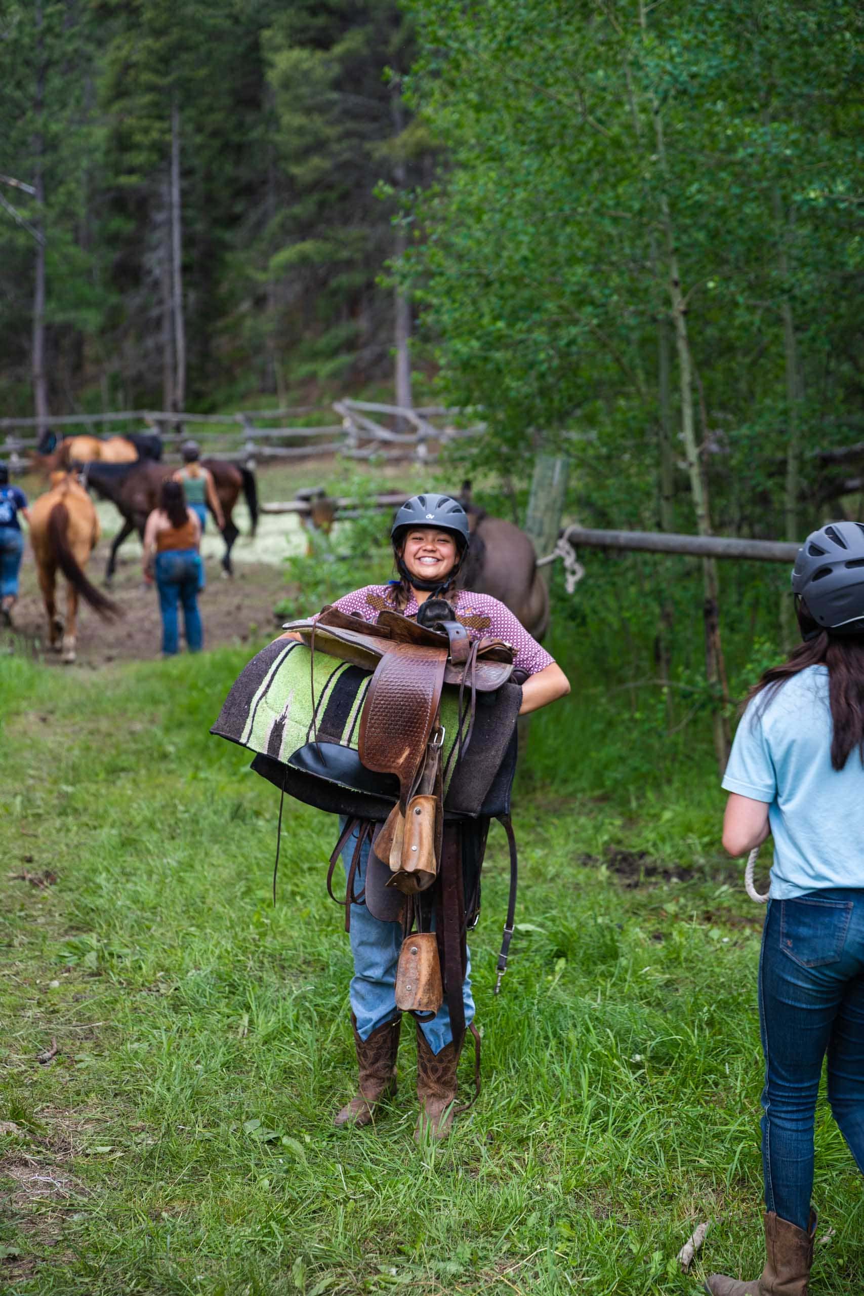 Girl holding saddle.